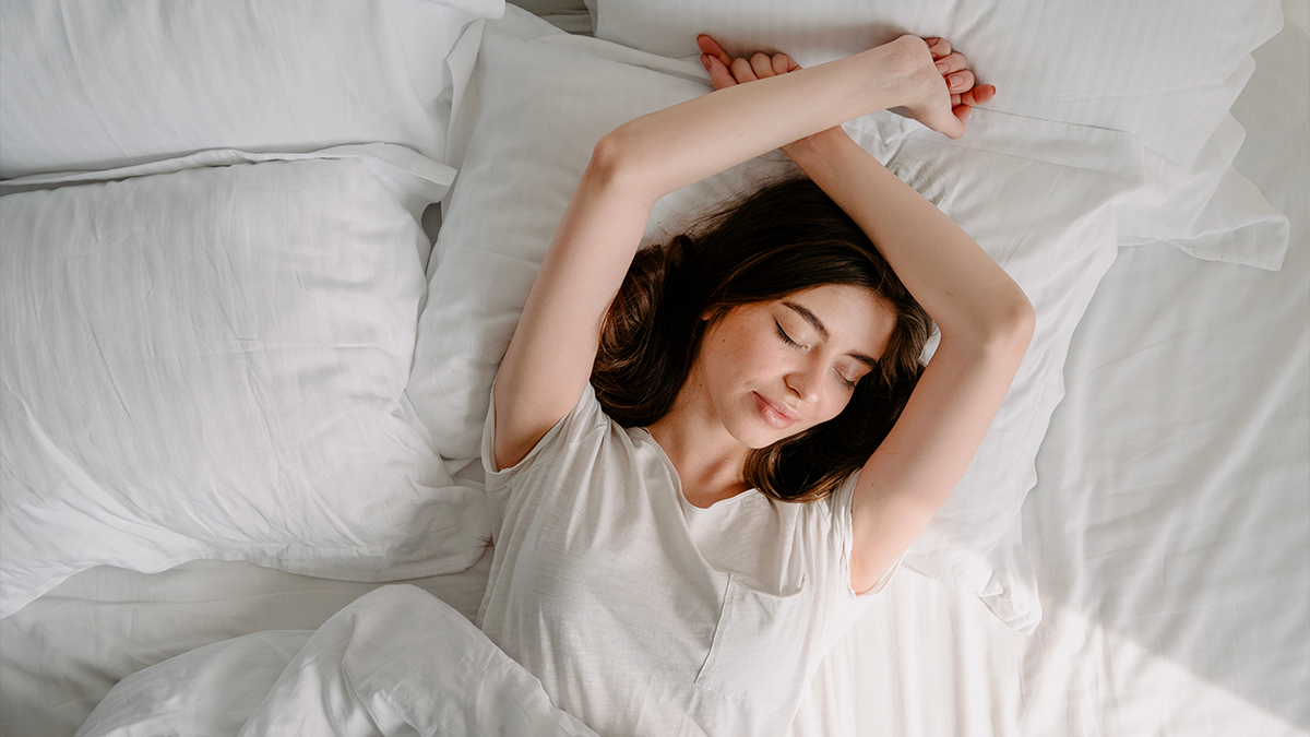 Donna che dorme in estate su lenzuola bianche