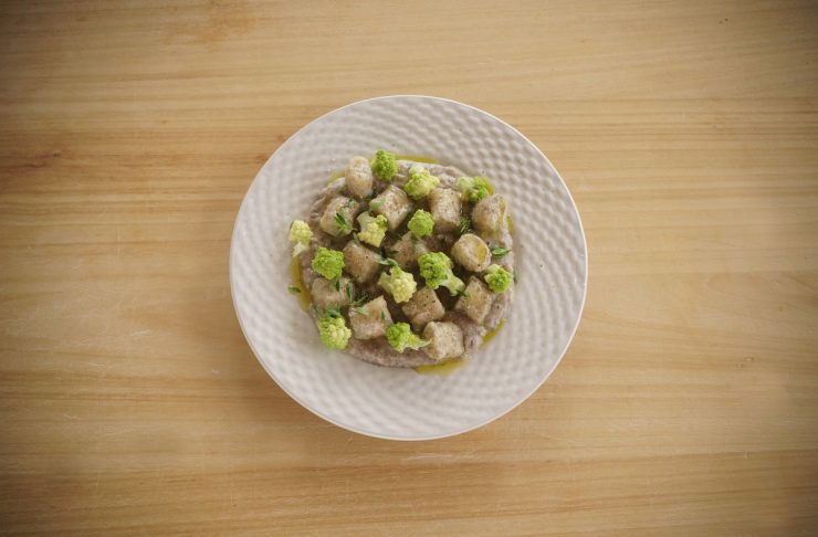 gnocchi di farro e ceci serviti con crema di legumi