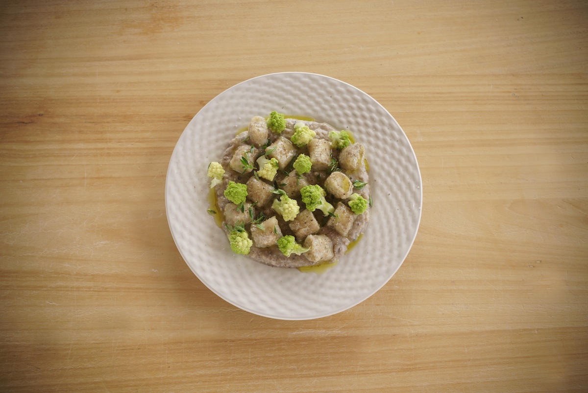 gnocchi di farro e ceci serviti con crema di legumi