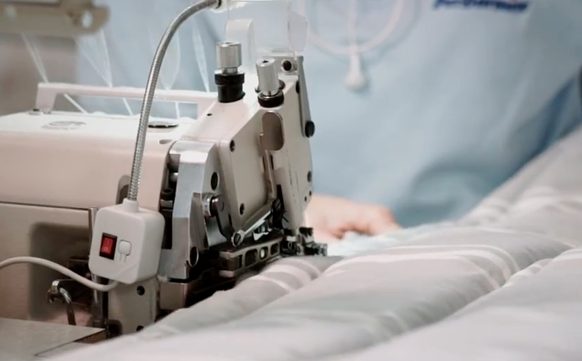materasso-made-in-italy-perdormire macchina da cucire industriale e operaia mentre cuce il rivestimento di un materasso made in Italy prodotto da PerDormire