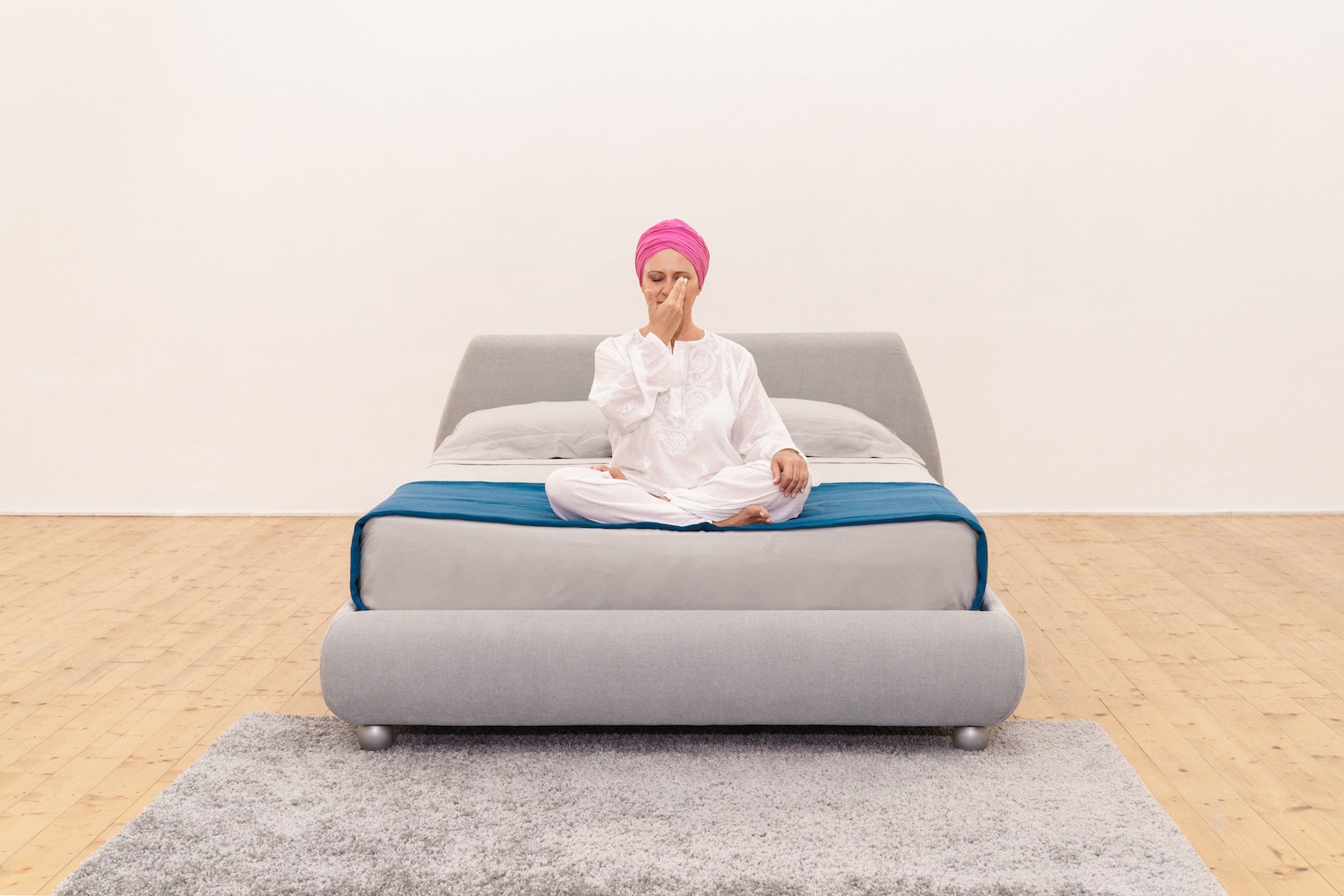 meditazione-tecniche-per-rilassarsi-3 donna su letto che esegue una tecnica di meditazione per rilassarsi respirando alternando le narici