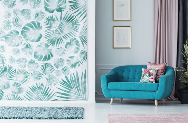 Una parete del soggiorno rivestita di carta da parati a stampa botanica
