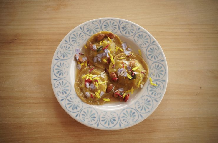 tortelli di zucca serviti con mandorle e fiori
